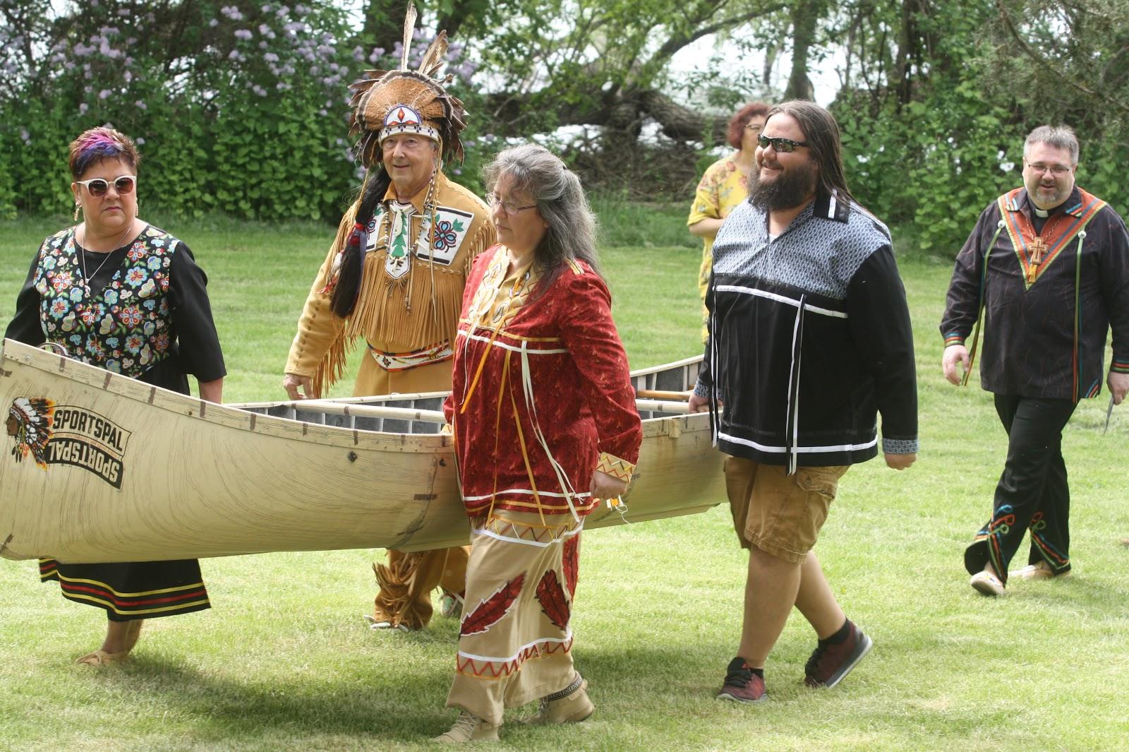 a group of people walking across a lush green field.