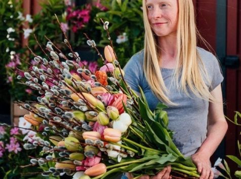 a woman holding a bunch of flowers in her hands.
