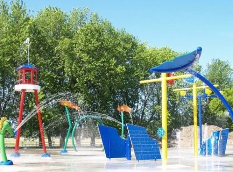 a children's play area with a water fountain and slides.