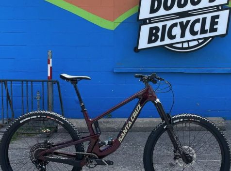 a mountain bike parked in front of a bicycle shop.