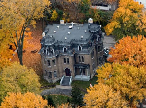 Image of a historic mansion amongst fall coloured trees
