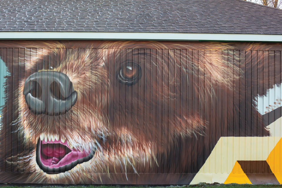 a painting of a brown bear on the side of a building.