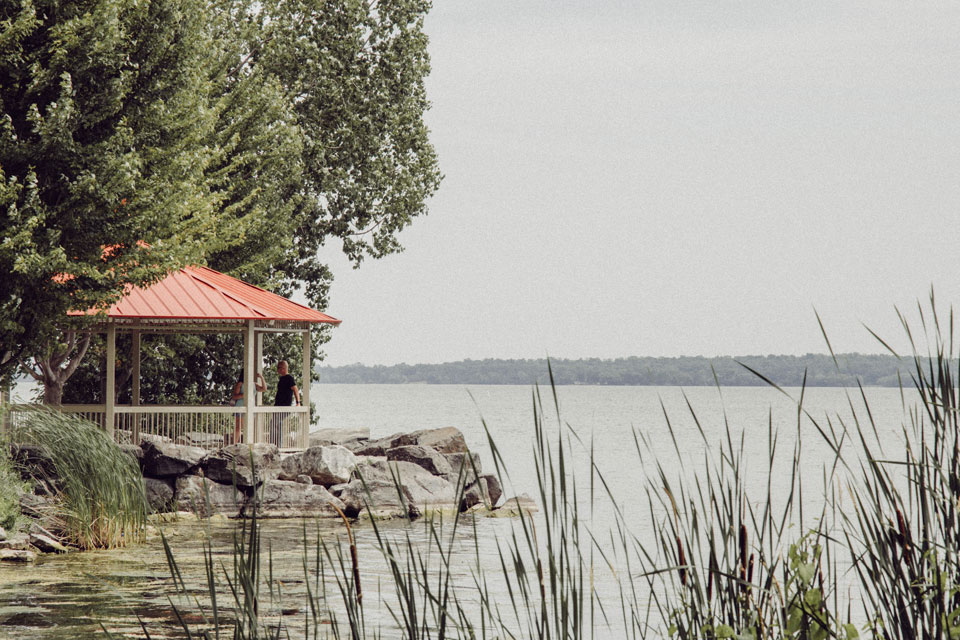 a gazebo sitting on the shore of a lake.