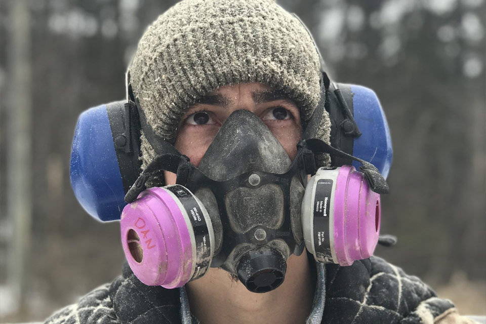 a man wearing a gas mask and a hat.