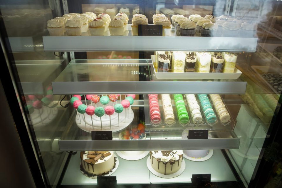 a display case filled with lots of different types of cakes.