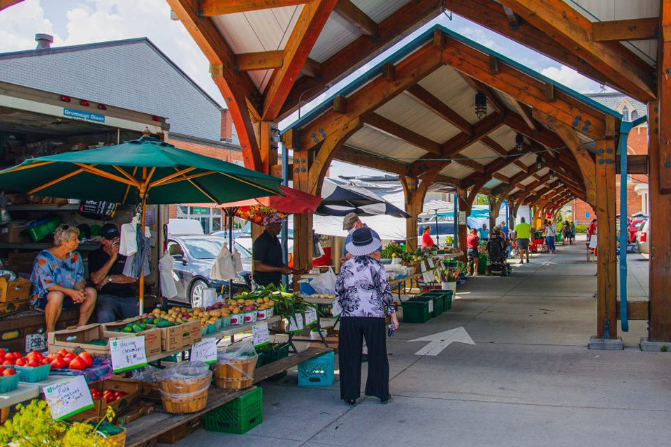 a farmer's market with people shopping for produce.
