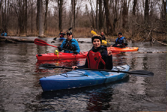 a group of people in kayaks paddling down a river.