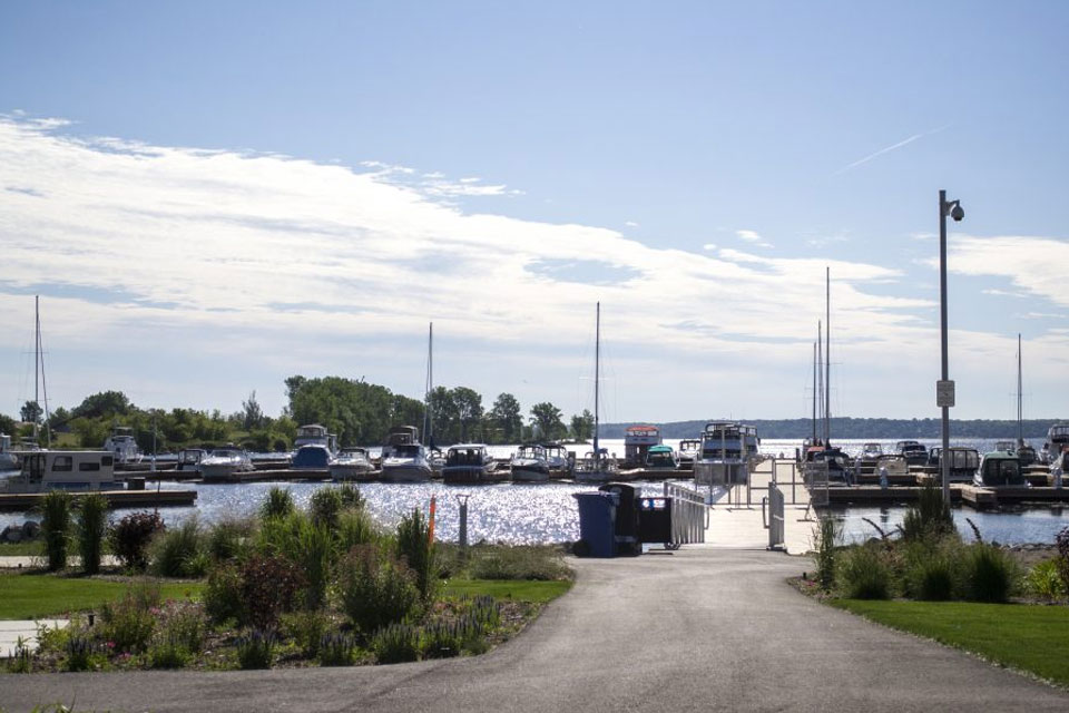 a path leading to a marina with boats in the water.