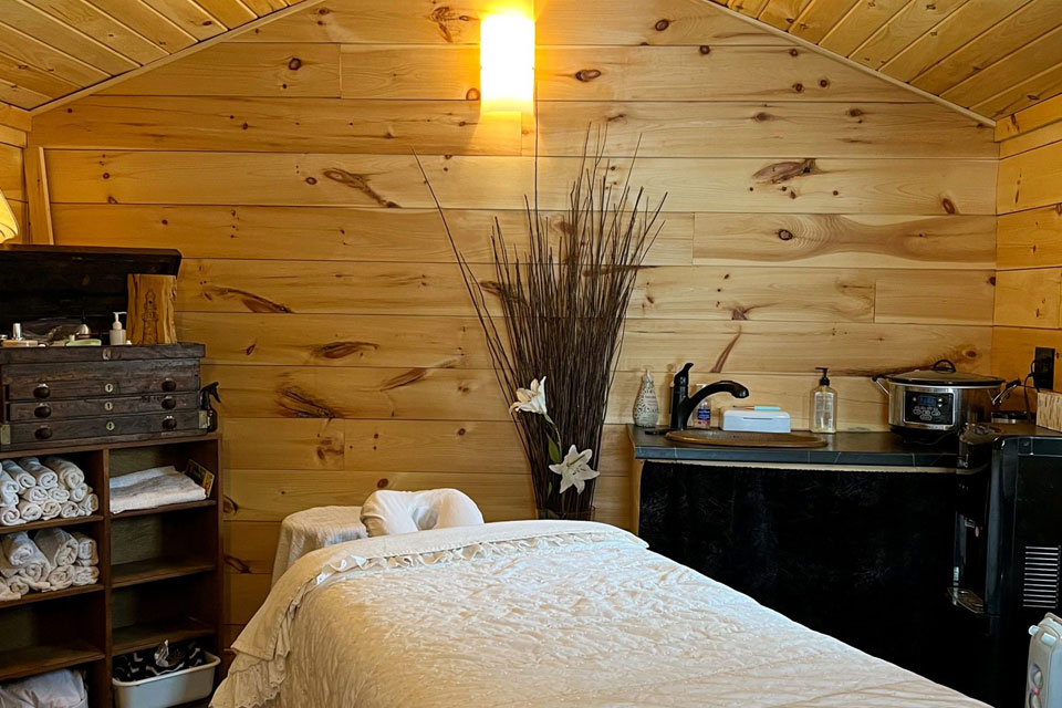 a bed in a room with wooden walls.