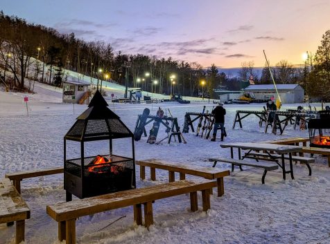 a ski resort with a fire pit in the snow.