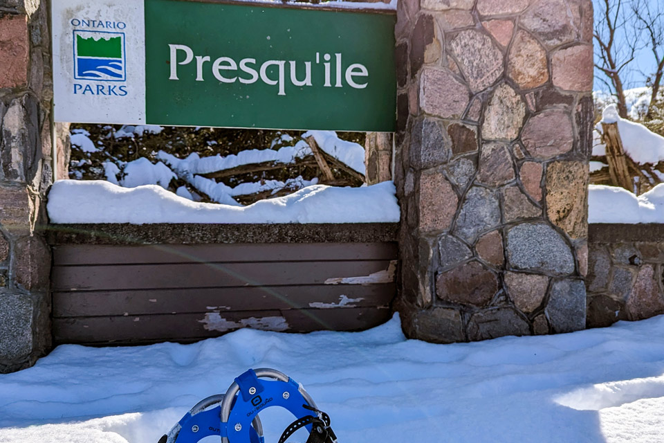 a pair of snowshoes in the snow next to a sign.