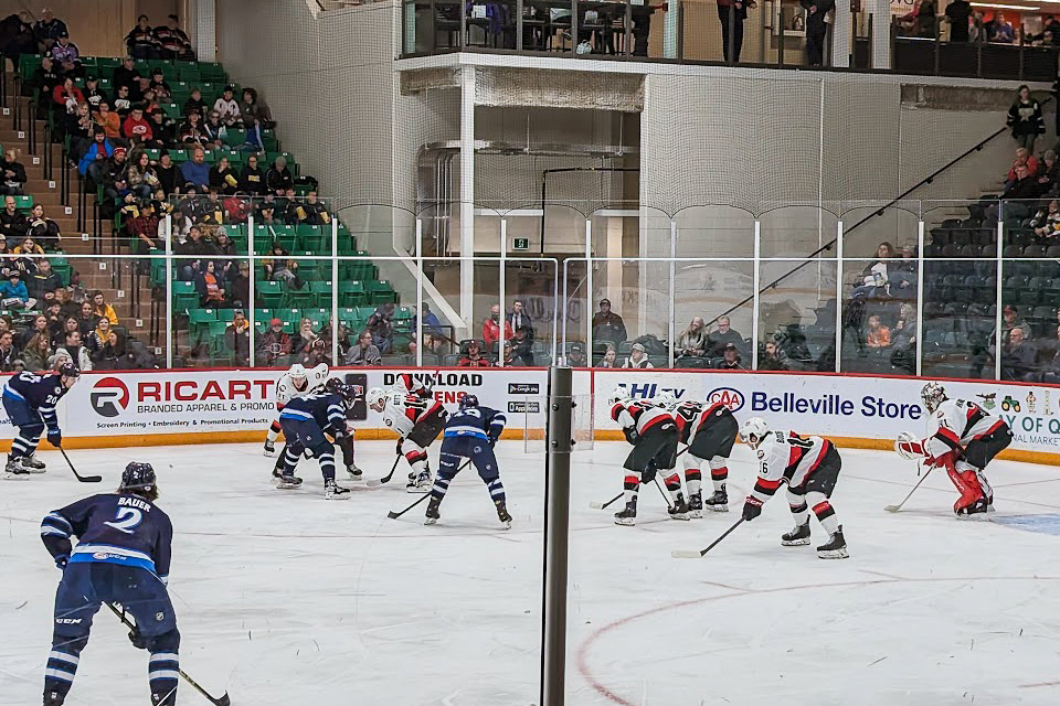 a hockey game is being played in front of a large crowd.