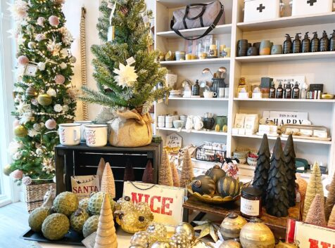 table and shelves in a boutique filled with various holiday and home decor