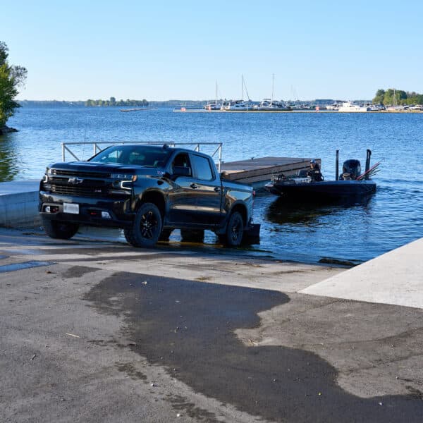 a pickup truck lowering a boat into a boat launch