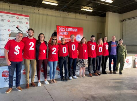 a large group of people wearing red shirts, each with a number printed on them to show $2 million, the campaign goal of the united way hastings and prince edward