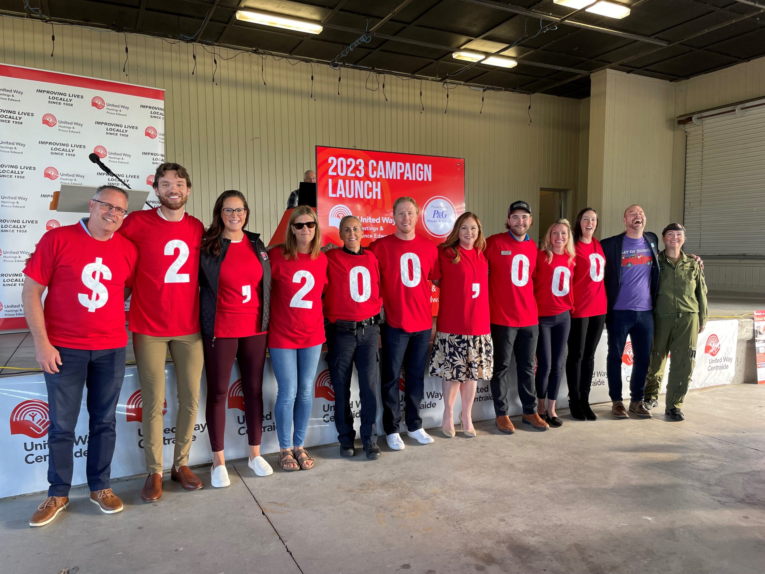 a large group of people wearing red shirts, each with a number printed on them to show $2 million, the campaign goal of the united way hastings and prince edward
