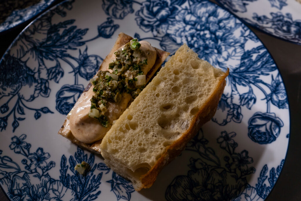 fresh bread with spreads on it on an ornate blue and white plate