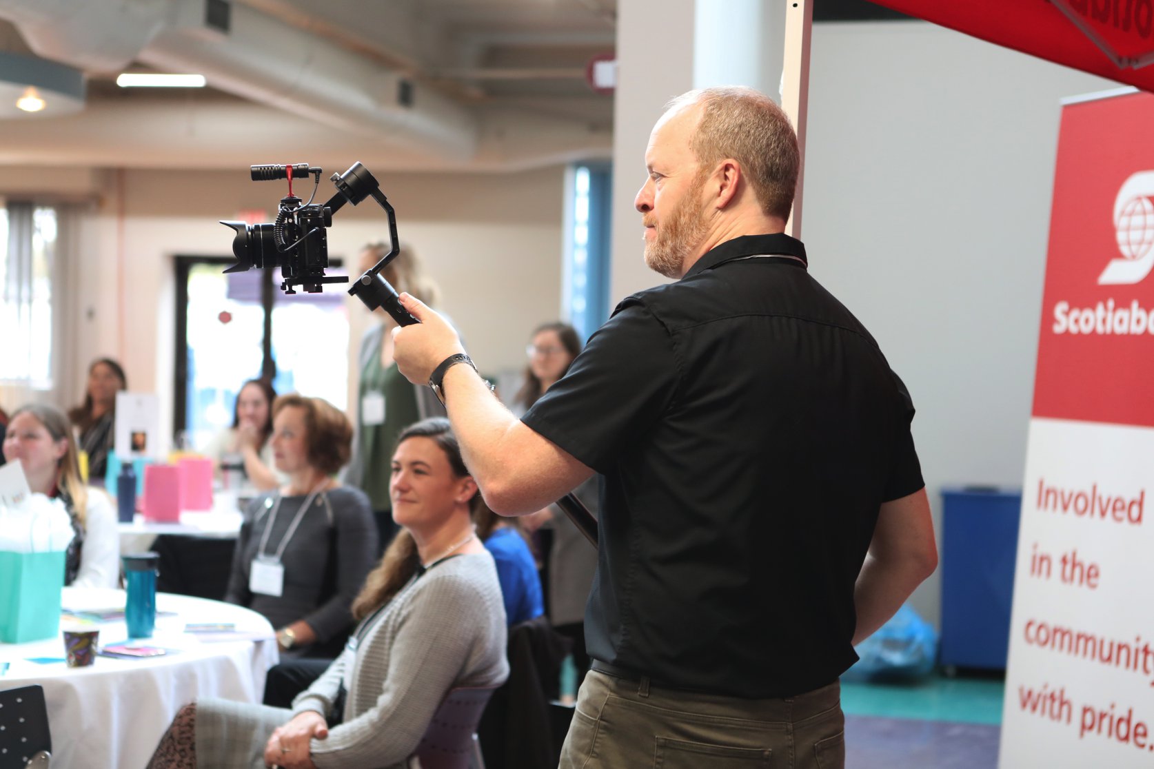 a man holding a camera filming a presentation
