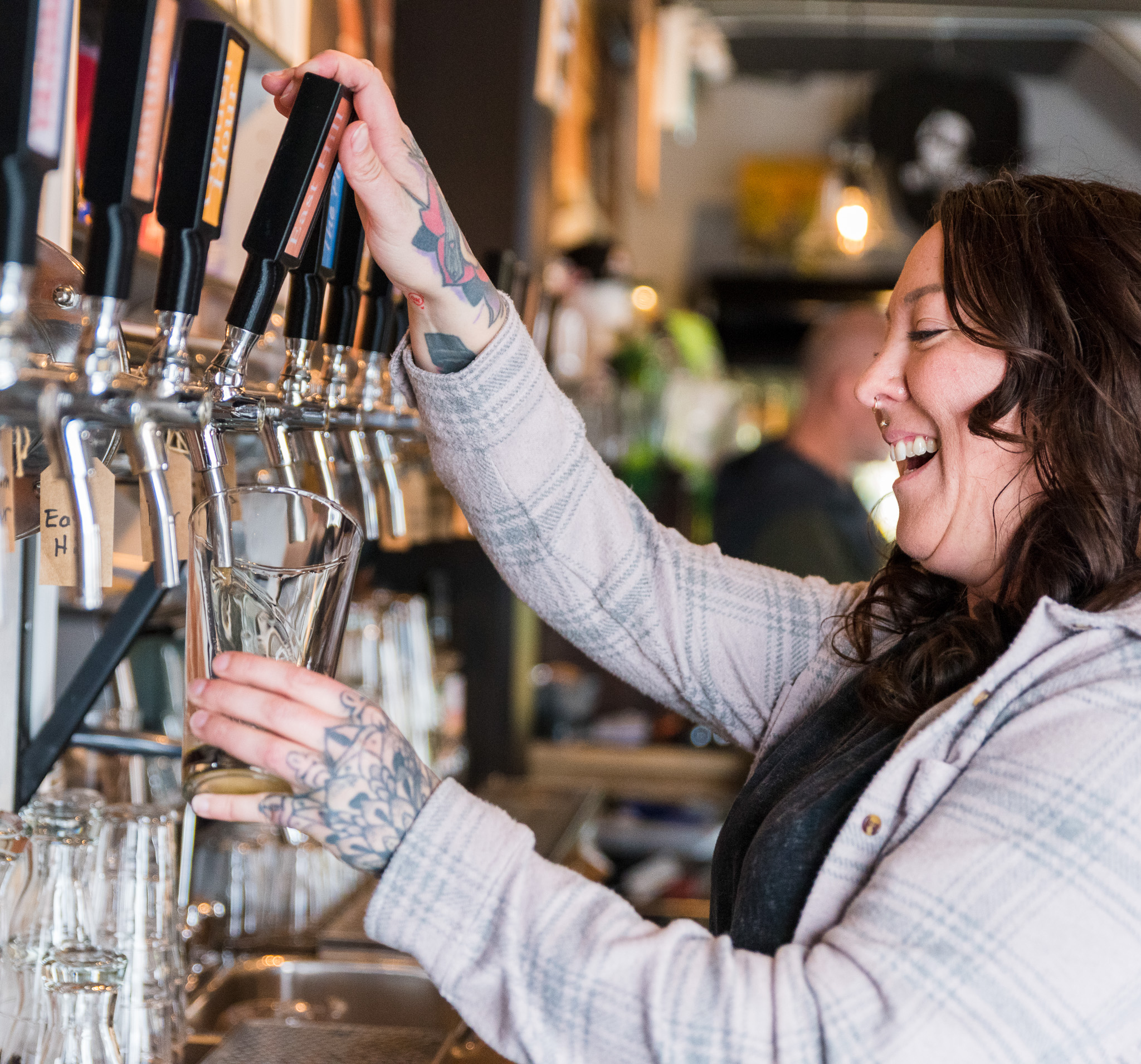 a woman pouring a draft beer
