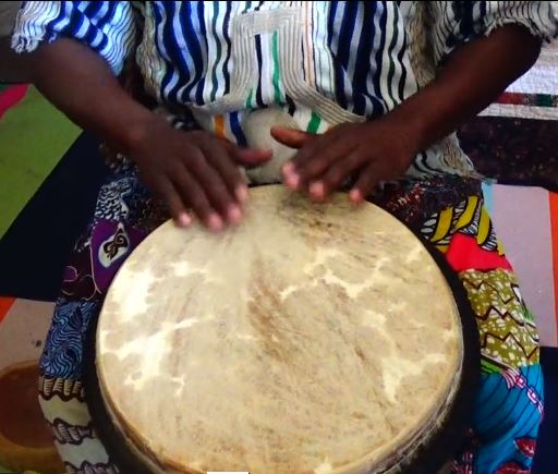 photo of a person playing a bongo drum.