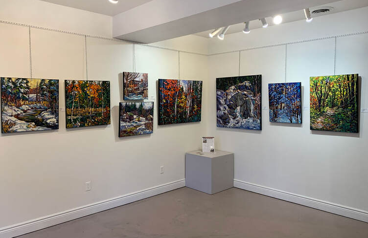 Image of art gallery with various canvas pieces of landscapes.