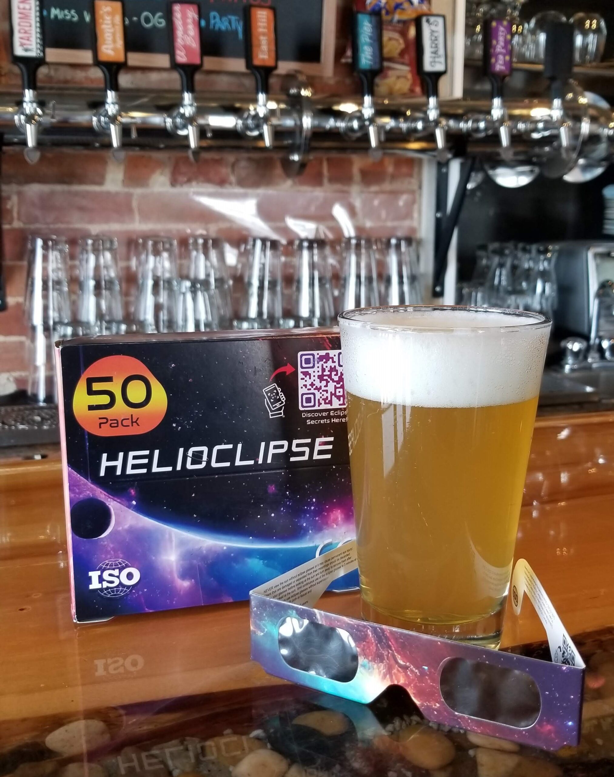 Image of a pint of beer and a pair of eclipse glasses.