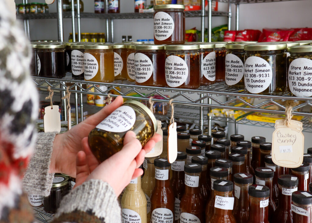 house-made canned preserves all labeled on shelves in a store