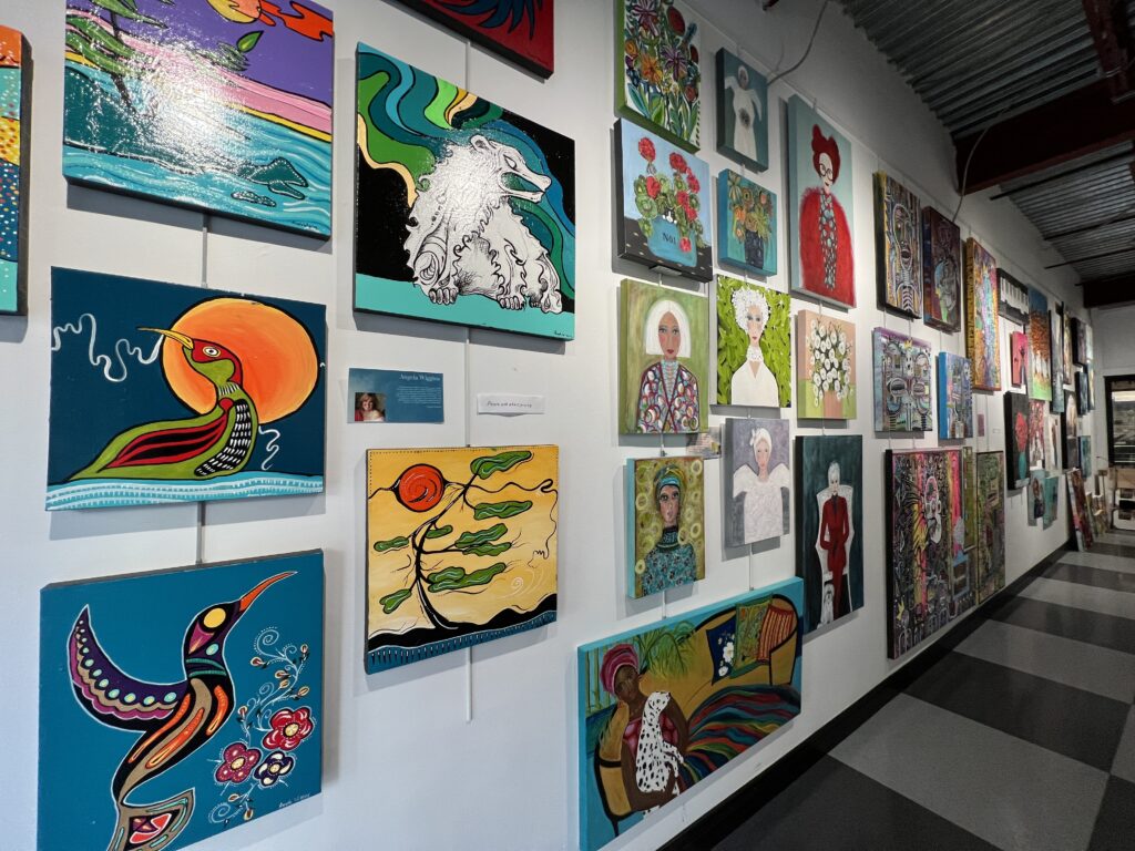 several paintings hanging on a gallery wall