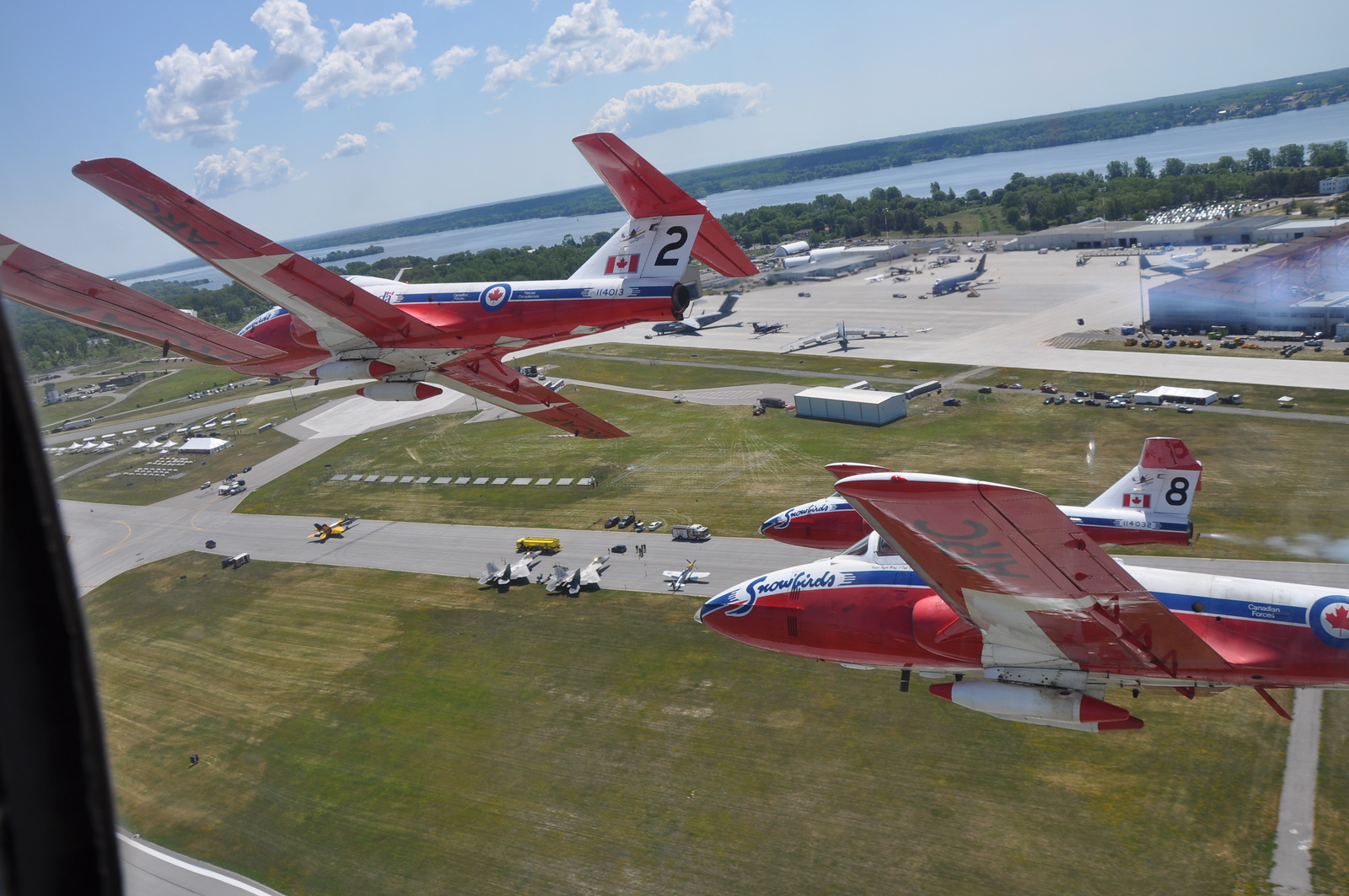 two snowbird airplanes flying over the CFB Trenton air base, taken from an adjacent plane