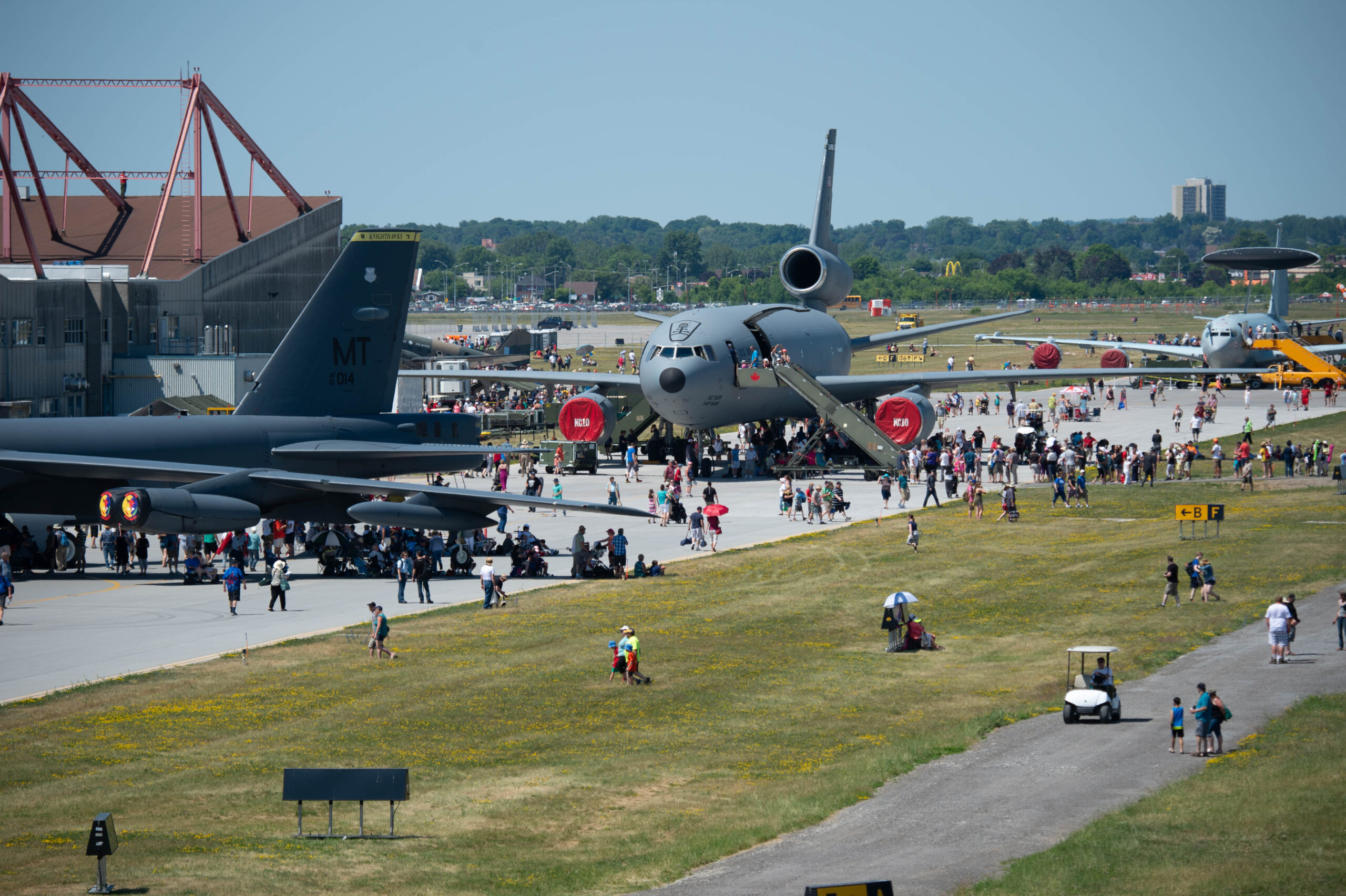 crowds gather around a large military airplane on display at an air show