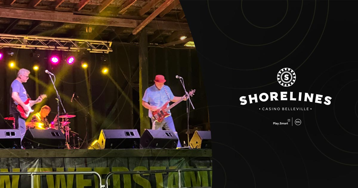 Photo of Decades band performing with Shorelines logo beside it