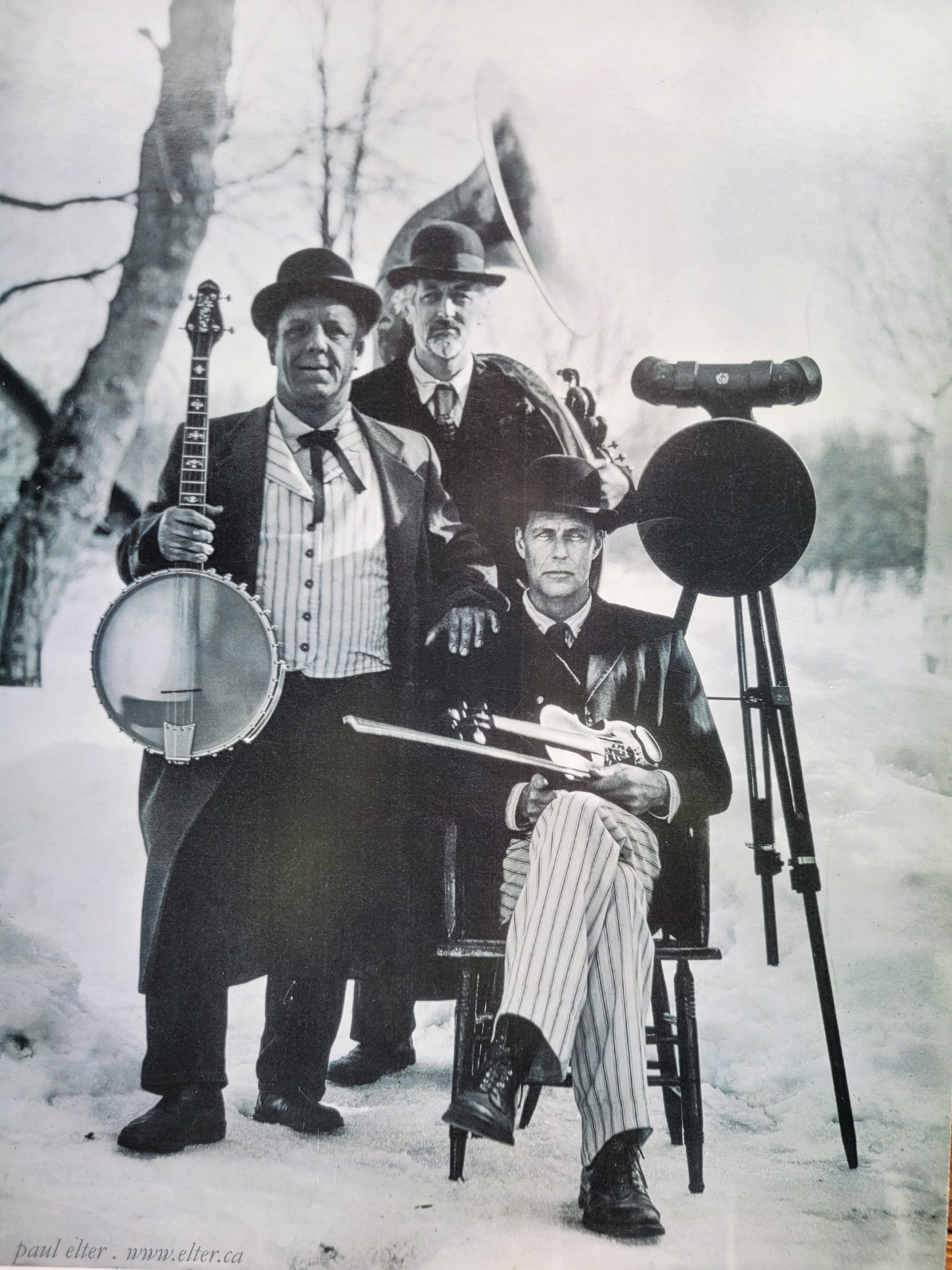 Photo of performers wearing old timey clothes in black and white.