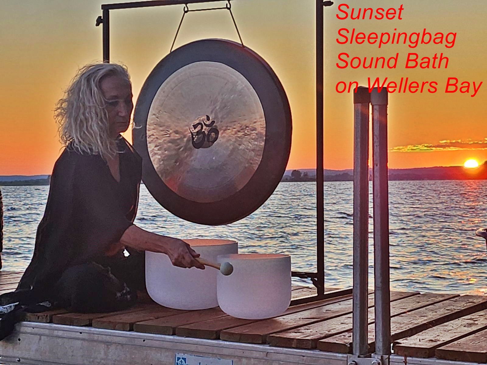 Photo of person conducting a sound bath on a dock.