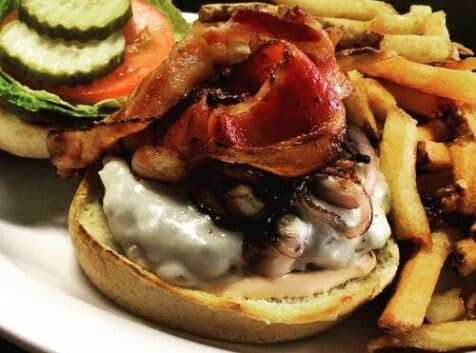 Image of a burger with bacon and side salad