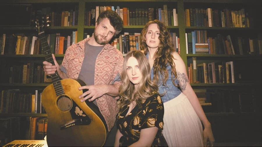 guy with guitar and two women posing