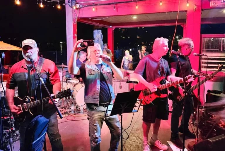 Band of men singing and playing instruments on stage