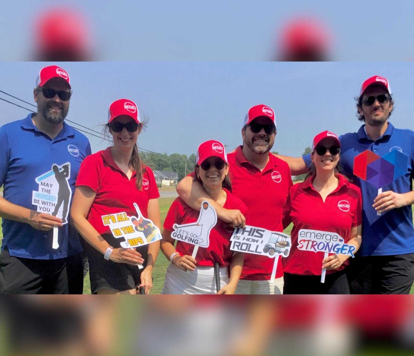 Group of golfers dressed in red, holding aspirational and funny signs