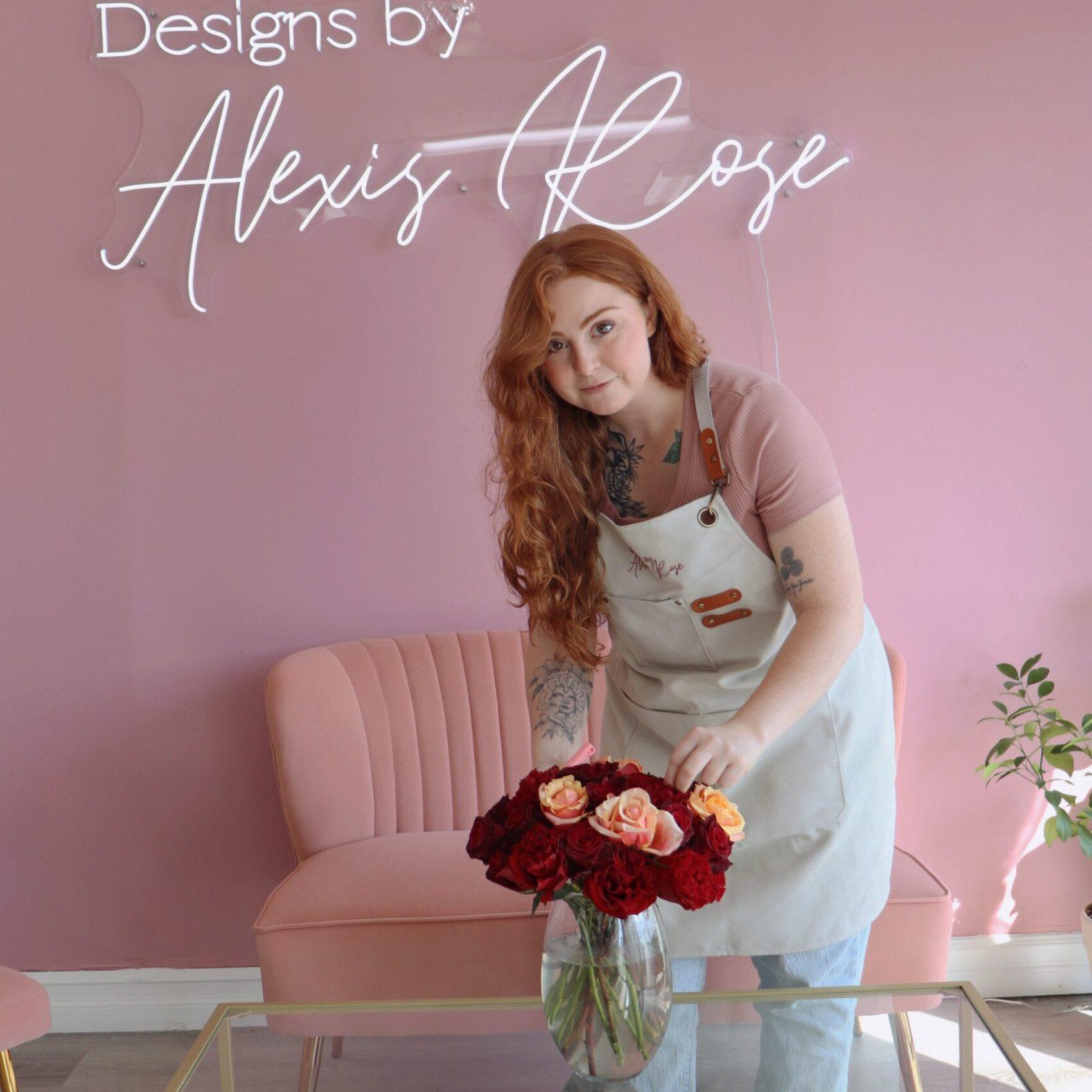Alexis Rose poses for a photo while arranging a bouquet of roses